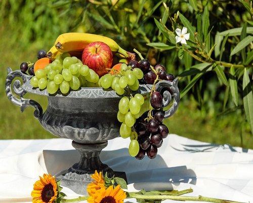 A person preparing a balanced healthy fruit bowl with seeds and nuts